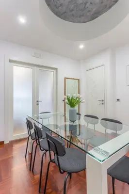 a dining room with a glass table and chairs at Family Art Flat in Rome