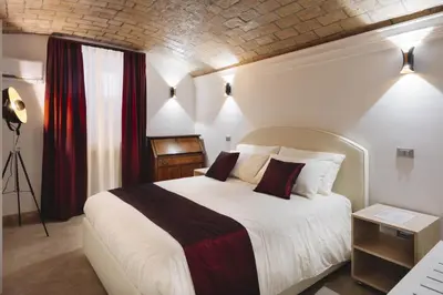a bedroom with a large white bed with red curtains at Domus Mariani - Cremera by Ghor in Rome
