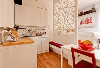a kitchen with white cabinets and a table with a bowl of fruit at Marte in Trevi in Rome