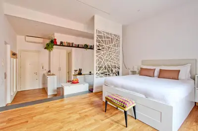 a white bedroom with a bed and a chair at Marte in Trevi in Rome