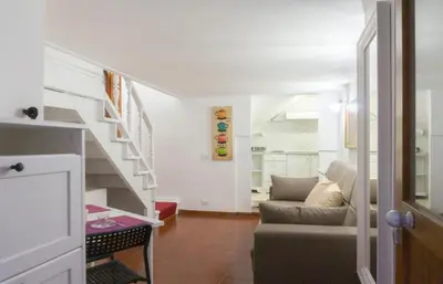 a living room with a couch and a staircase at Introvabile! Casa Roma centro, Campo de Fiori in Rome