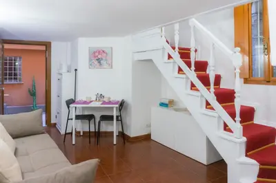 a living room with a staircase and a table at Introvabile! Casa Roma centro, Campo de Fiori in Rome