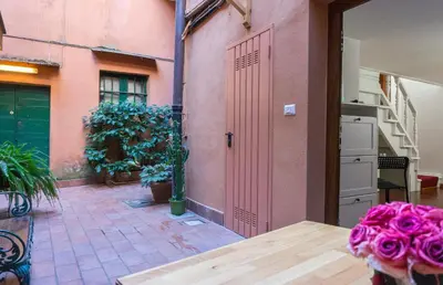 a room with a pink door and a table with flowers at Introvabile! Casa Roma centro, Campo de Fiori in Rome
