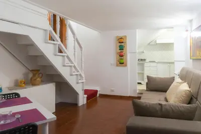 a living room with a staircase and a couch at Introvabile! Casa Roma centro, Campo de Fiori in Rome