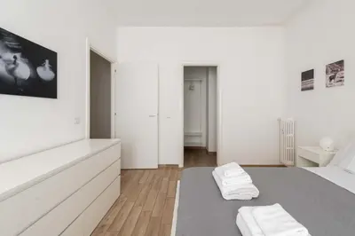a white bedroom with a bed with two white towels on it at LoveRhome Apartment 2 in Rome