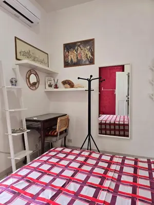 a bedroom with a bed and a table and a desk at Oasi San Pietro in Rome