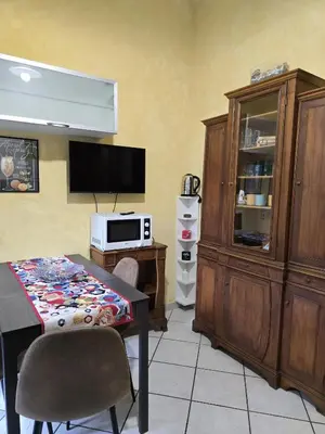 a dining room with a table and a tv and a cabinet at Oasi San Pietro in Rome