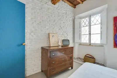 a bedroom with a wooden dresser and a window at Fori Imperiali Luxury Apartment in Rome