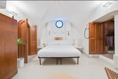 a white bedroom with a bed and a mirror at Fori Imperiali Luxury Apartment in Rome
