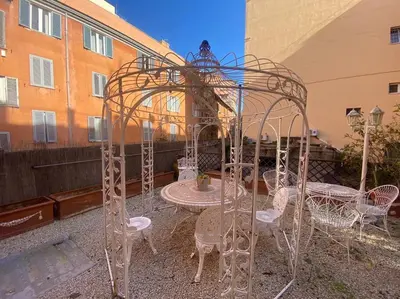 a metal gazebo with tables and chairs in a courtyard at Fori Imperiali Luxury Apartment in Rome