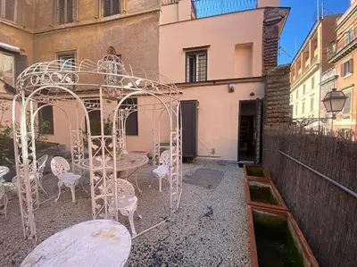 a gazebo with chairs and a table in a courtyard at Fori Imperiali Luxury Apartment in Rome
