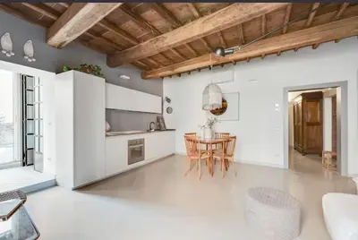 a kitchen and dining room with white walls and a table at Fori Imperiali Luxury Apartment in Rome