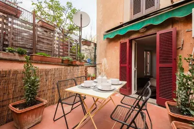 a patio with a table and chairs on a balcony at Trastevere Zen Home-ZENO 33 in Rome