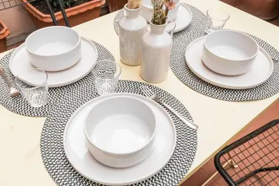 a table with plates and glasses on a table at Trastevere Zen Home-ZENO 33 in Rome