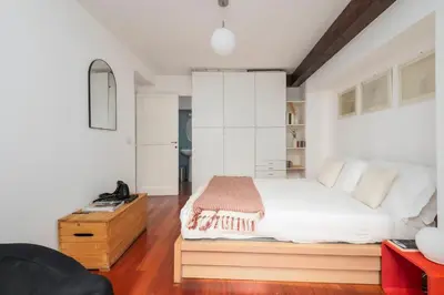 a bedroom with a large bed with white cabinets at Trastevere Zen Home-ZENO 33 in Rome