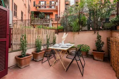a table and chairs on a patio with potted plants at Trastevere Zen Home-ZENO 33 in Rome