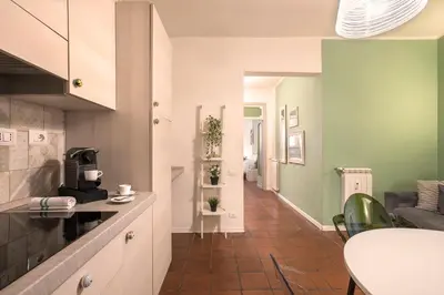 a kitchen with green and white walls and a table at Nettuno Apartment in Rome