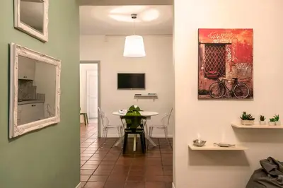 a living room with a table and a mirror at Nettuno Apartment in Rome