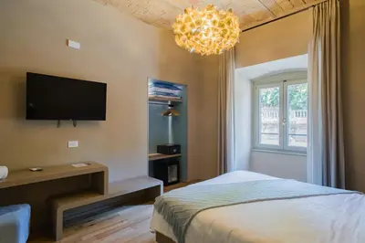 a bedroom with a bed and a tv and a chandelier at 163 BOUTIQUE HOTEL in Rome