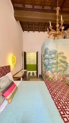 a bedroom with a large bed and a chandelier at The Grand Tour Bed & Breakfast in Rome