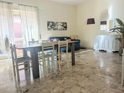 a living room with a table and a blue couch at Casa de mi Zia in Rome