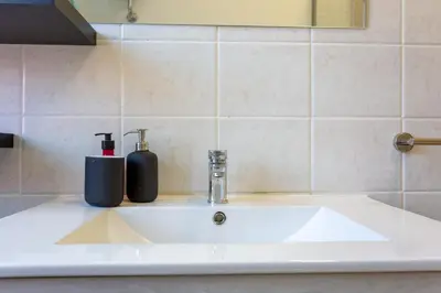 a bathroom sink with a soap dispenser on it at St.Peter station Holiday apartment in Rome