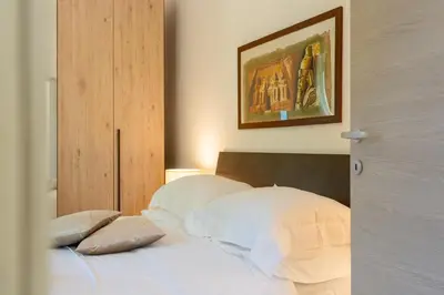 a bed with two pillows and a picture on the wall at St.Peter station Holiday apartment in Rome