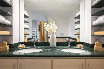 a bathroom with two sinks with a vase of flowers at Montebello Style in Rome