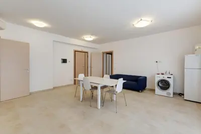 a living room with a table and a blue couch at Guesthouse Vassallo Uno in Rome