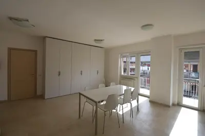 a dining room with white cabinets and a table and chairs at Guesthouse Vassallo Uno in Rome