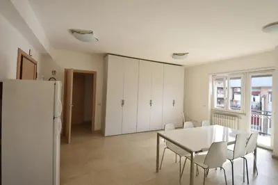 a dining room with a table and chairs and a refrigerator at Guesthouse Vassallo Uno in Rome