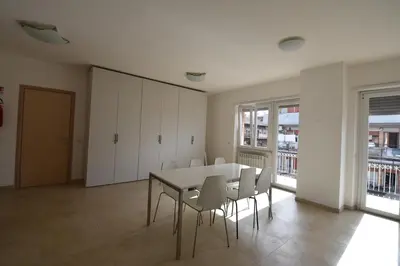 a dining room with a table and white chairs at Guesthouse Vassallo Uno in Rome