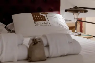 a bed with a pile of towels on it at Restart Accommodations Colle Oppio e Paganini in Rome
