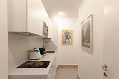 a kitchen with white cabinets and a stove top oven at Restart Accommodations Colle Oppio e Paganini in Rome