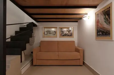 a living room with a couch and a staircase at Restart Accommodations Colle Oppio e Paganini in Rome