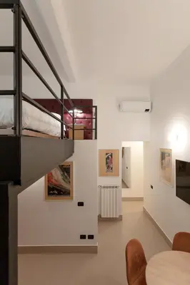 a staircase in a room with a bed and a table at Restart Accommodations Colle Oppio e Paganini in Rome