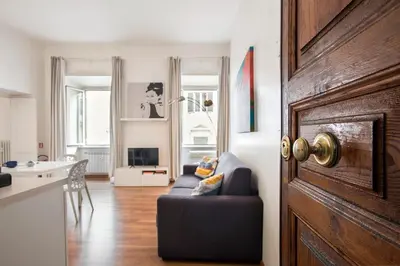 a living room with a couch and a kitchen at Minerva 2 Apartment in Rome