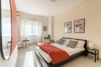 a bedroom with a large bed and a mirror at Maison Lumiere, Design Apt 5 min from Tiburtina Station in Rome