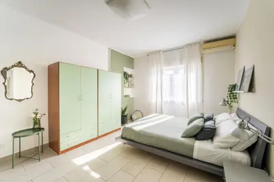 a bedroom with a large bed and a cabinet at Maison Lumiere, Design Apt 5 min from Tiburtina Station in Rome