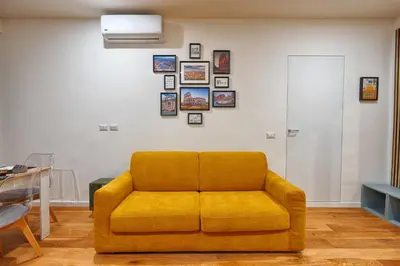 a yellow couch in a living room with pictures on the wall at Home Trastevere.62 in Rome