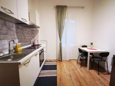 a kitchen with a sink and a table with chairs at Friendly Apartment in Rome