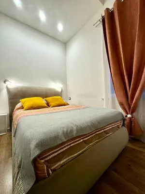 a bedroom with a bed with two yellow pillows at Friendly Apartment in Rome