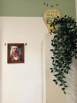 a plant on a wall next to a door with a picture at Friendly Apartment in Rome