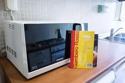a microwave oven with two books on a counter at Vatican Fabio Massimo Apartment - Stay Inn Rome Experience in Rome