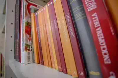 a row of books sitting on a shelf at Vatican Fabio Massimo Apartment - Stay Inn Rome Experience in Rome