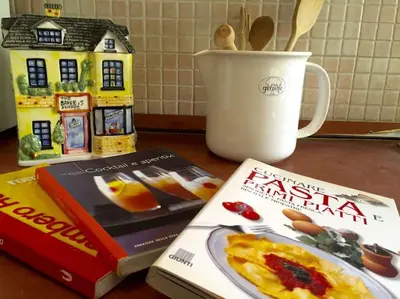 two books sitting on a table with a cup of coffee at Vatican Fabio Massimo Apartment - Stay Inn Rome Experience in Rome