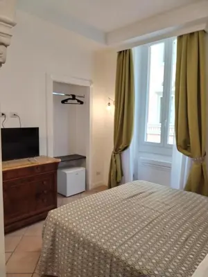 a bedroom with a bed and a dresser and a window at B&B L'Esquilina in Rome