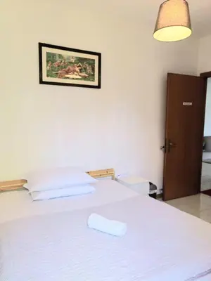a bedroom with a white bed with a towel on it at RAHIMA GUEST HOUSE in Rome