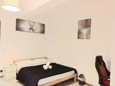 a bedroom with a bed and two pictures on the wall at RAHIMA GUEST HOUSE in Rome