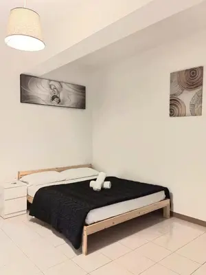 a bedroom with a large bed with a black blanket at RAHIMA GUEST HOUSE in Rome